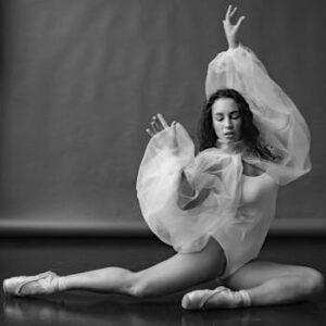 Black and white photo of a ballet dancer elegantly posed in a studio setting.