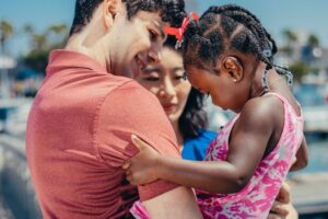 A joyful moment captured of a diverse family bonding outdoors on a bright summer day.