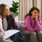 Couple engaging in a therapy session indoors with a mental health expert.